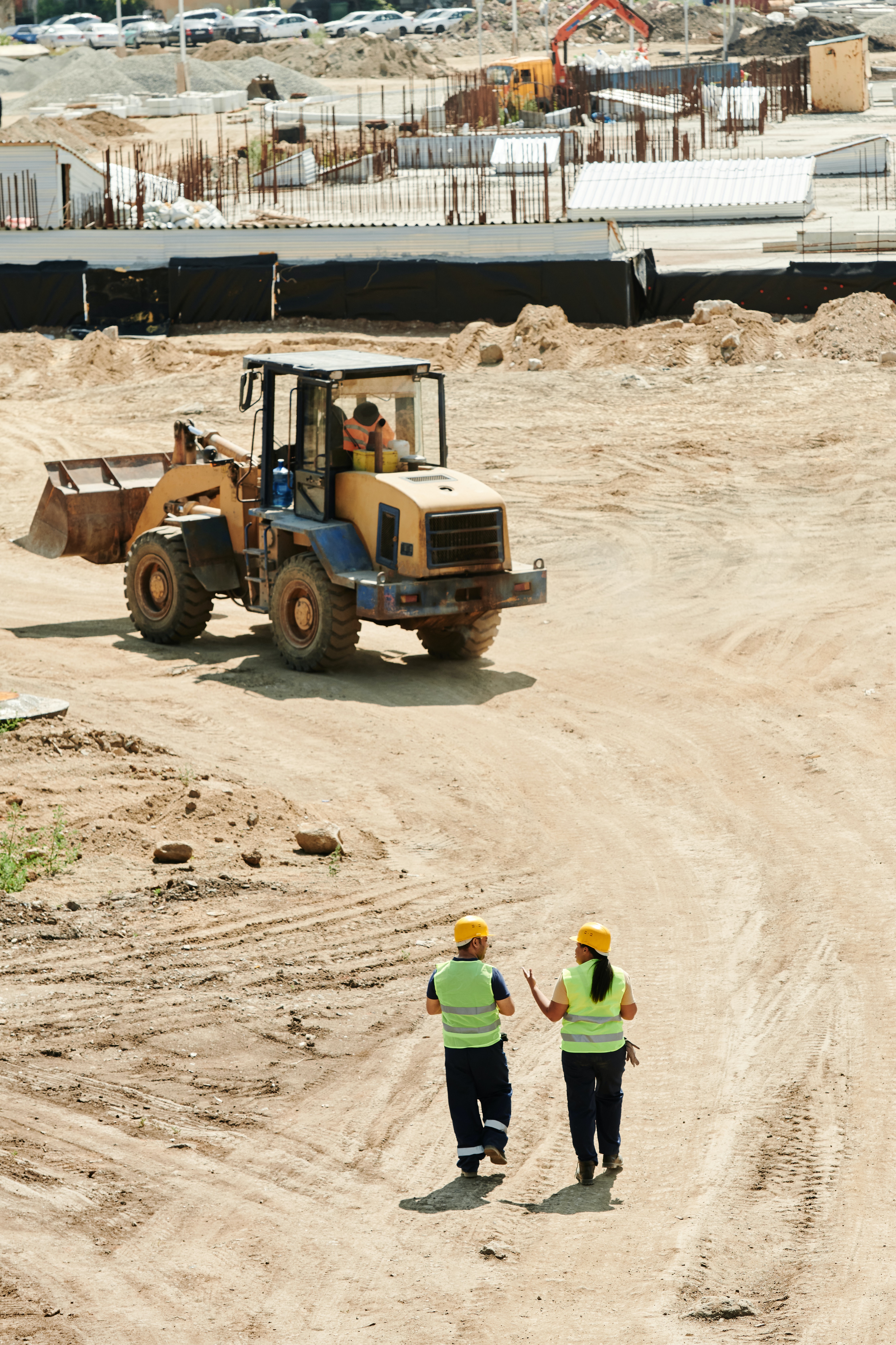 Two people walking on a construction site